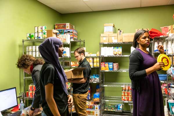 Photo of volunteers at Barney's Pantry stacking canned food items.