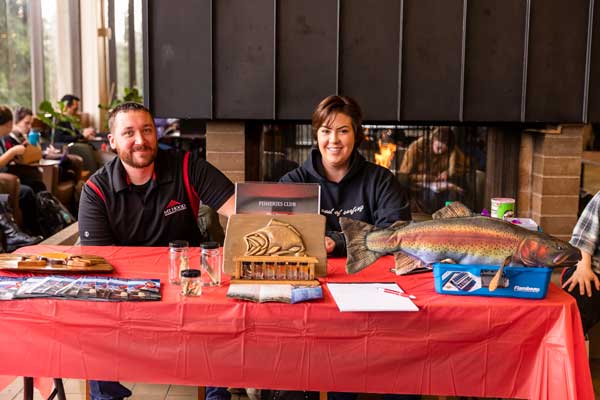 Photo of a man and woman sitting with their table for the Fisheries Club.