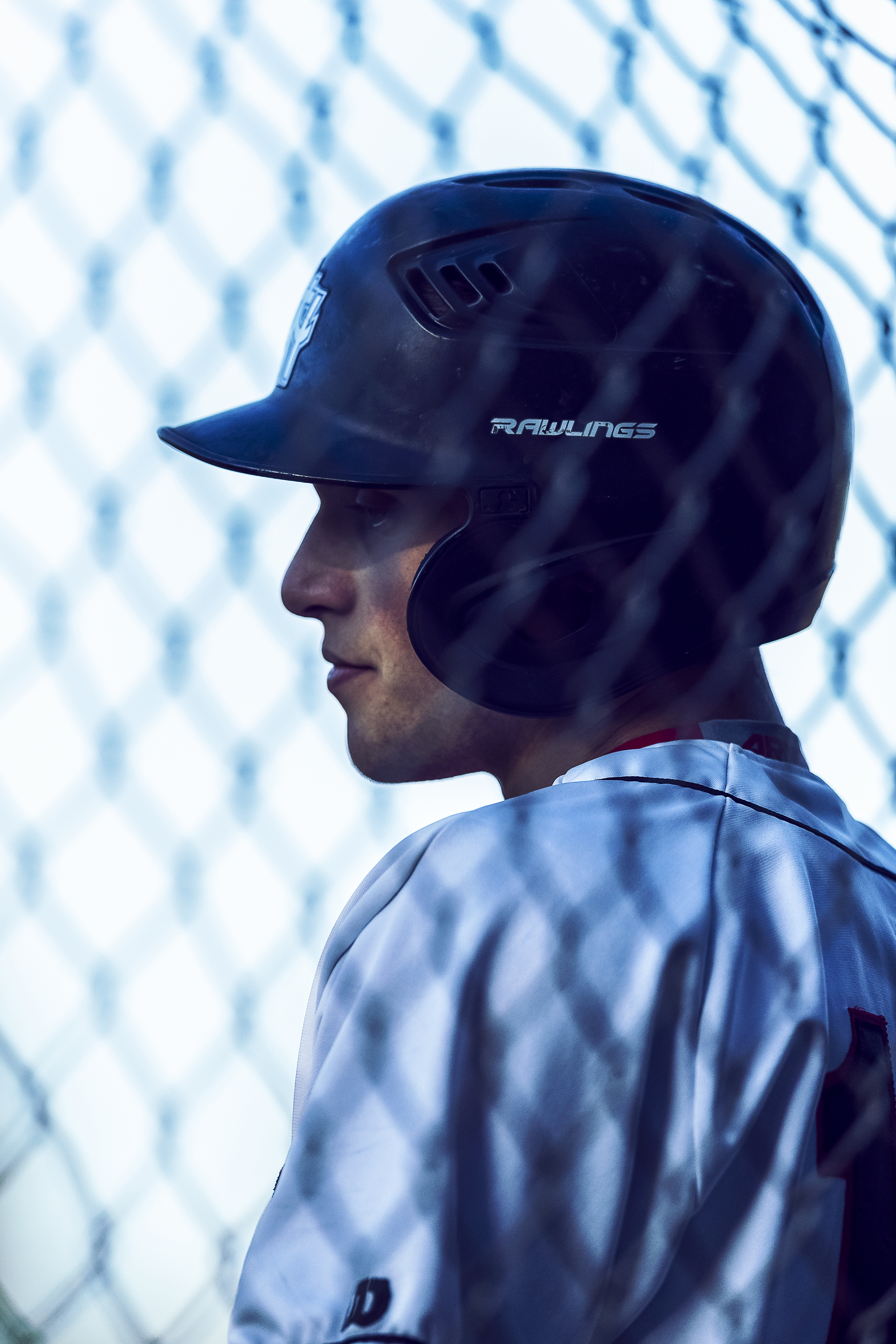 Candid side portrait of Saint player through fence