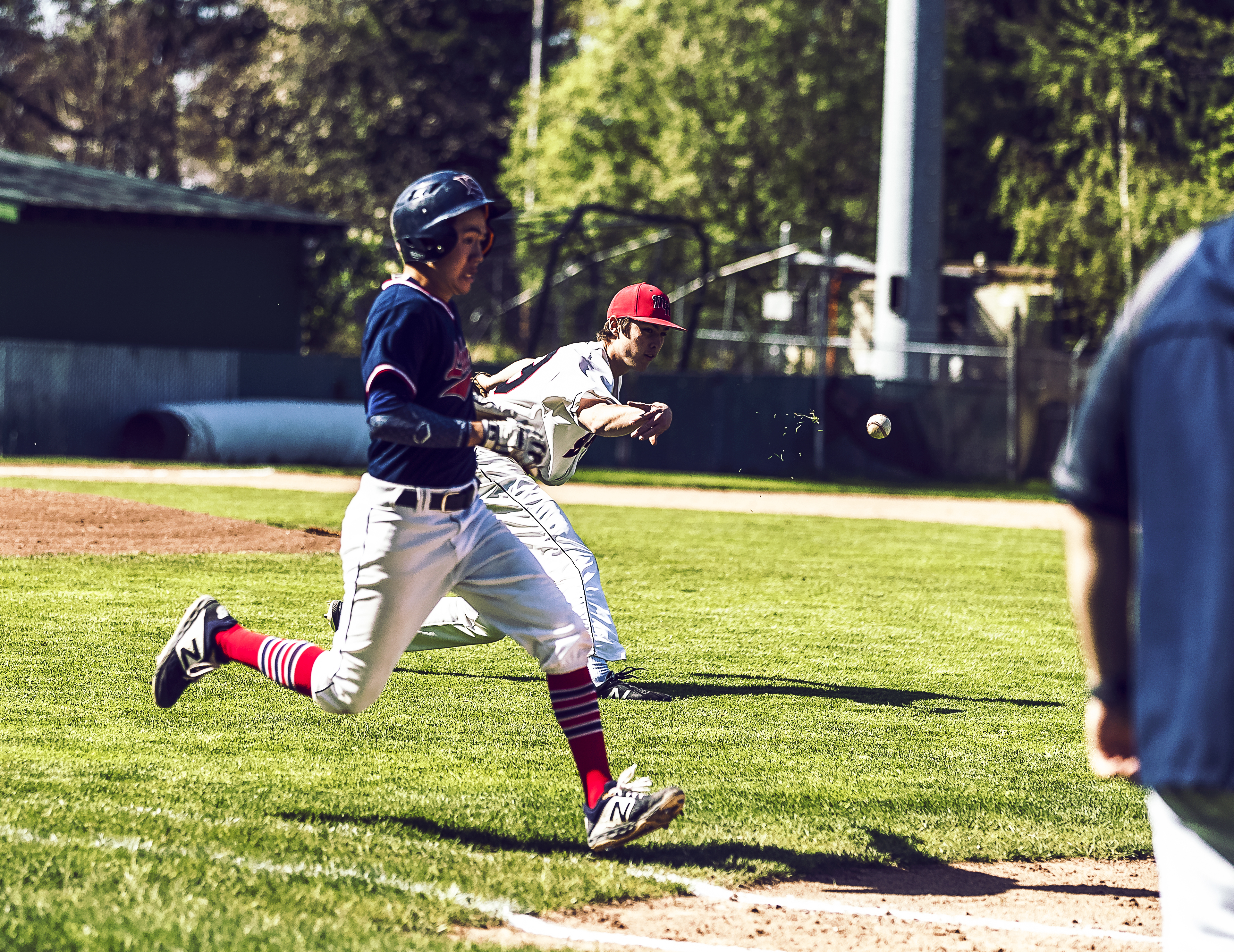 A Laker player running into home plate as a Saint player throws the ball to home plate