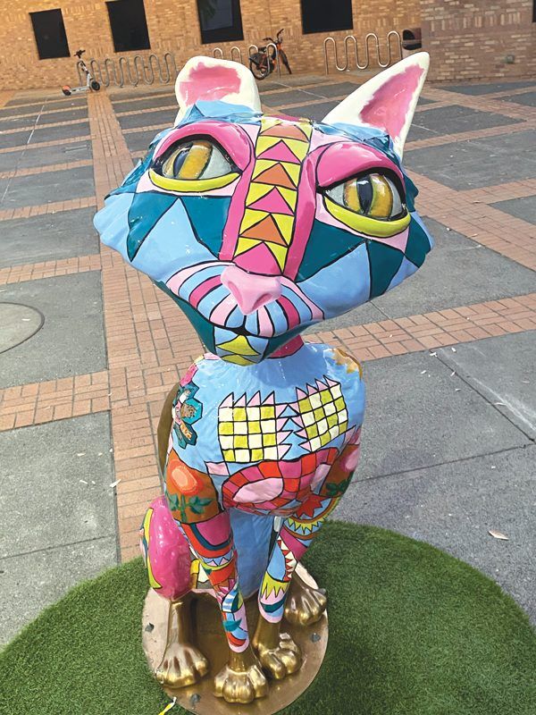 Individual photos of cat statues that are painted creatively