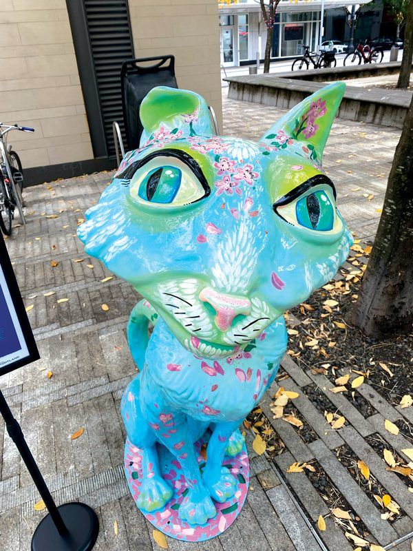 Individual photos of cat statues that are painted creatively